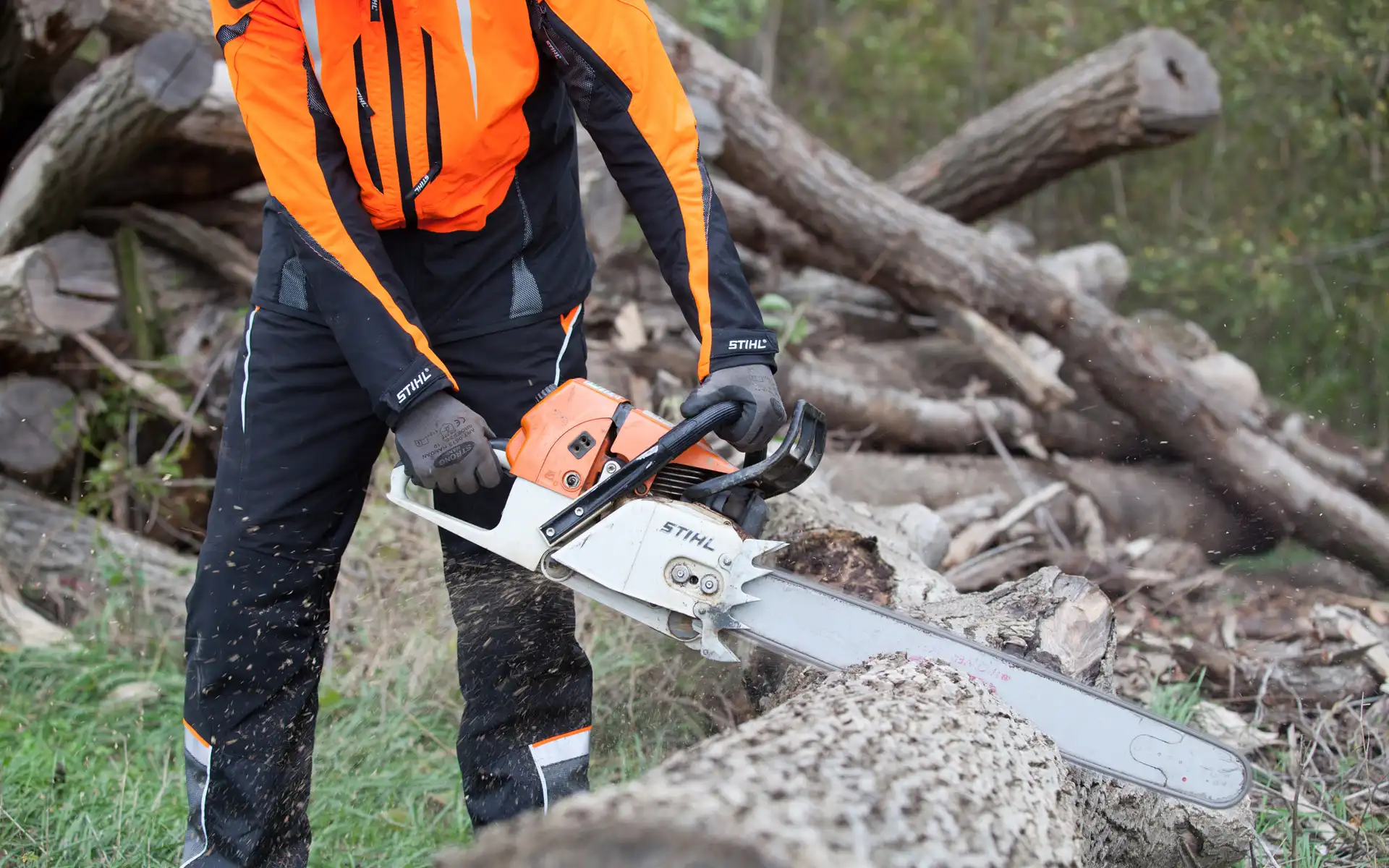 Ein Mitarbeiter von Göschlholz bearbeitet einen Baumstamm mit einer leistungsstarken Kettensäge.